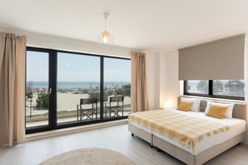a bedroom with a bed and a large window at Milena in Mamaia Sat/Năvodari