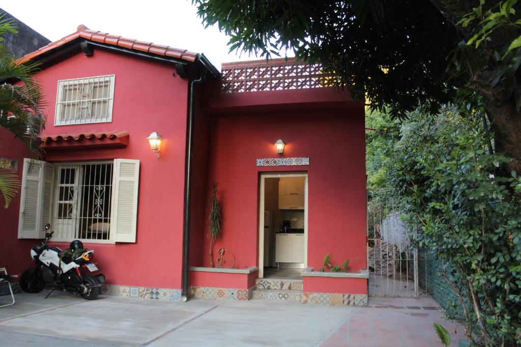 a red house with a motorcycle parked in front of it at Taguato Recoleta in Asuncion