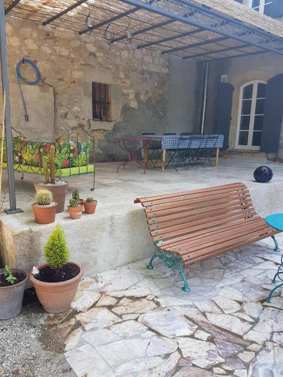 a wooden bench sitting on a patio with potted plants at domaine de Capoulade in Narbonne