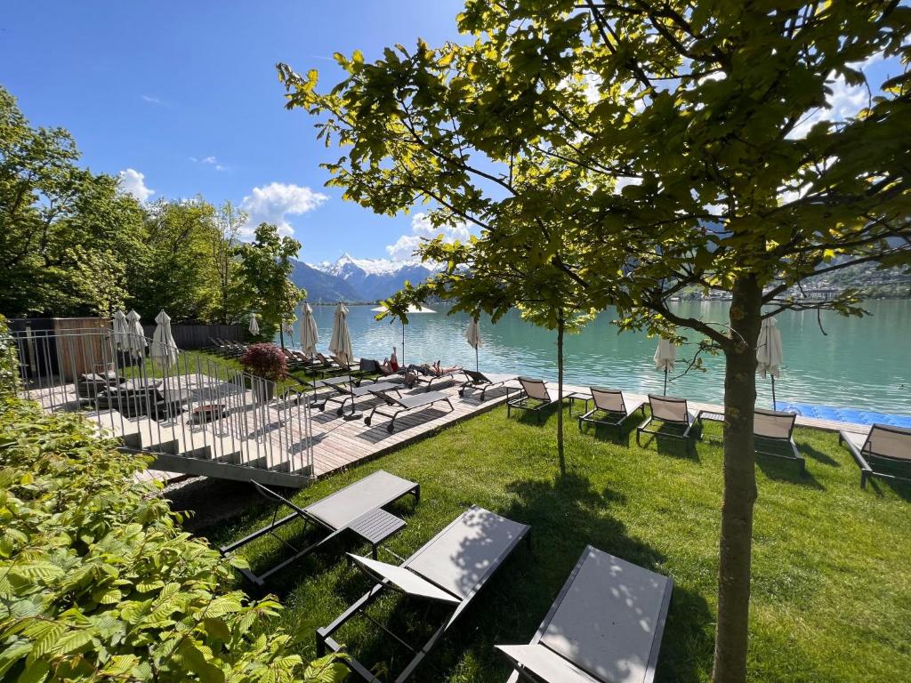 a group of chairs and tables and a lake at Apartment Residence Bellevue by Interhome in Zell am See