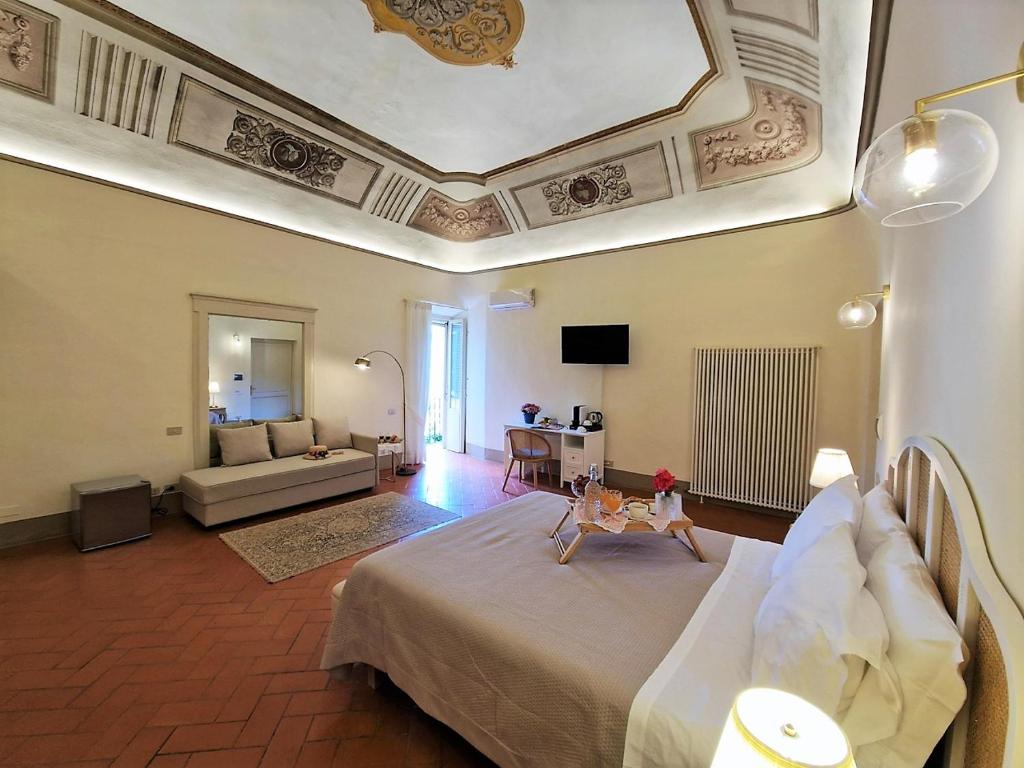 une grande chambre avec un grand lit et un salon dans l'établissement Palazzo Rosselmini, à Pise