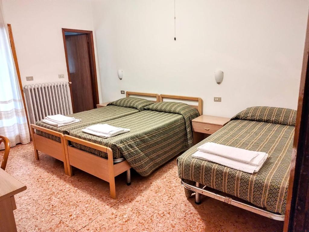 een slaapkamer met 2 bedden, een bureau en een tafel bij Hotel Ristorante Miramonti in Consuma