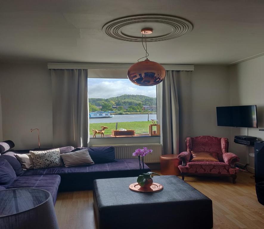 sala de estar con sofá púrpura y ventana en De Koperen Geit en Kanne