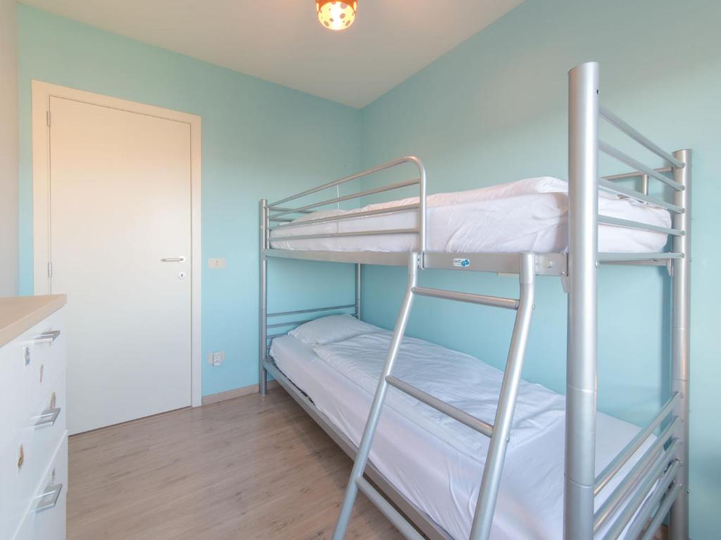 two bunk beds in a room with blue walls at Apartment Zeebries by Interhome in Bredene
