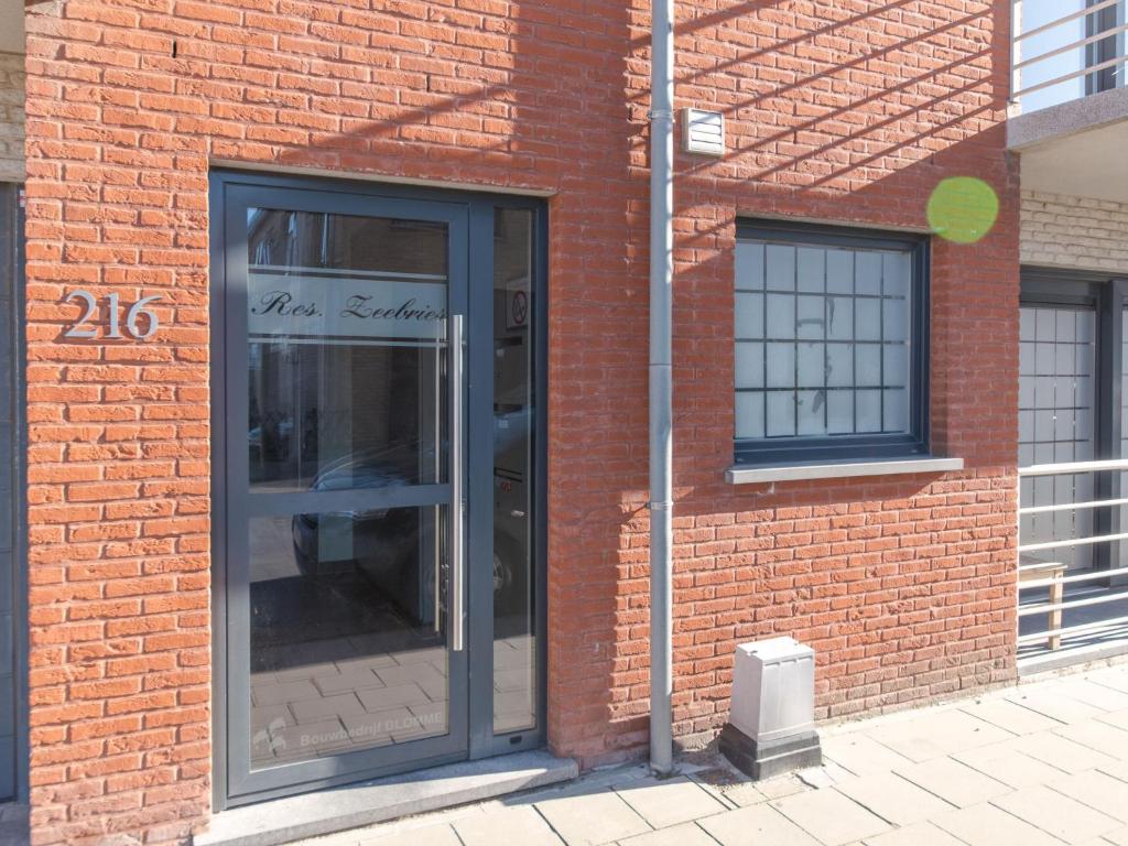 a brick building with a revolving door on it at Apartment Zeebries by Interhome in Bredene