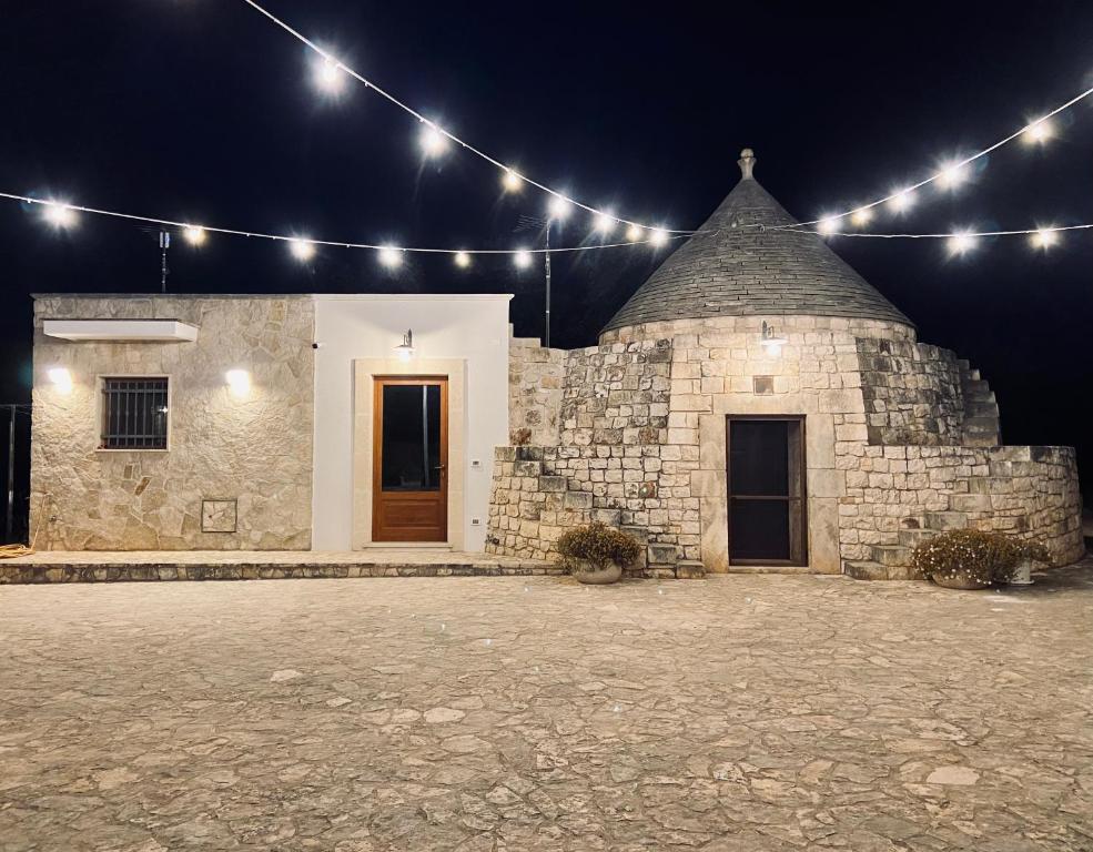 ein Steingebäude mit Lichtern in der Nacht in der Unterkunft TRULLO DEL BOSCHETTO in Carovigno