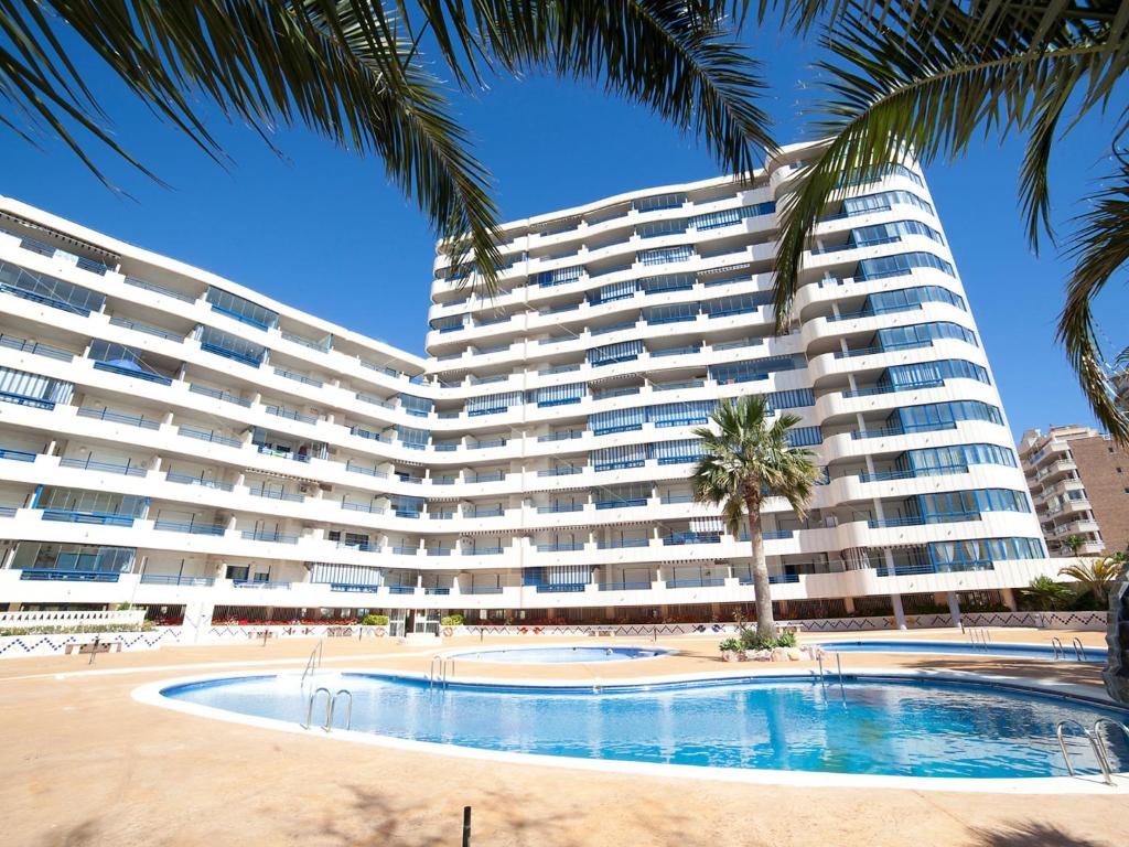 een groot appartementencomplex met een zwembad en palmbomen bij Apartment Turquesa Beach-6 by Interhome in Calpe