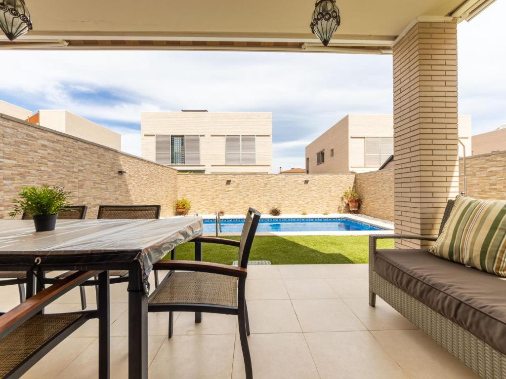 een patio met een tafel en stoelen en een zwembad bij Holiday Home Reig by Interhome in Cambrils