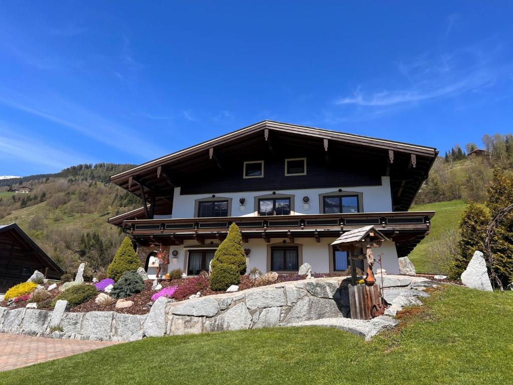 a house on a hill with a stone wall at Apartment Hüttaler by Interhome in Dorf