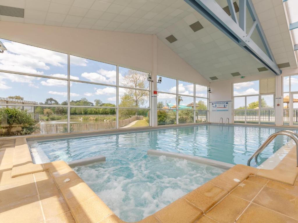 una gran piscina cubierta con jacuzzi en Holiday Home New Cottage de 2020 by Interhome, en Saint-Hilaire-de-Riez