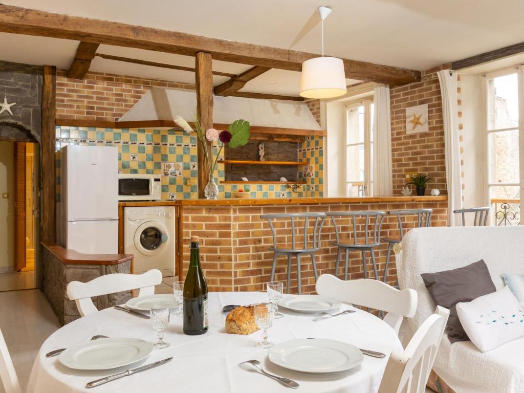 una cocina con una mesa con platos blancos y una botella de vino en Apartment le Malouin by Interhome en Saint-Malo