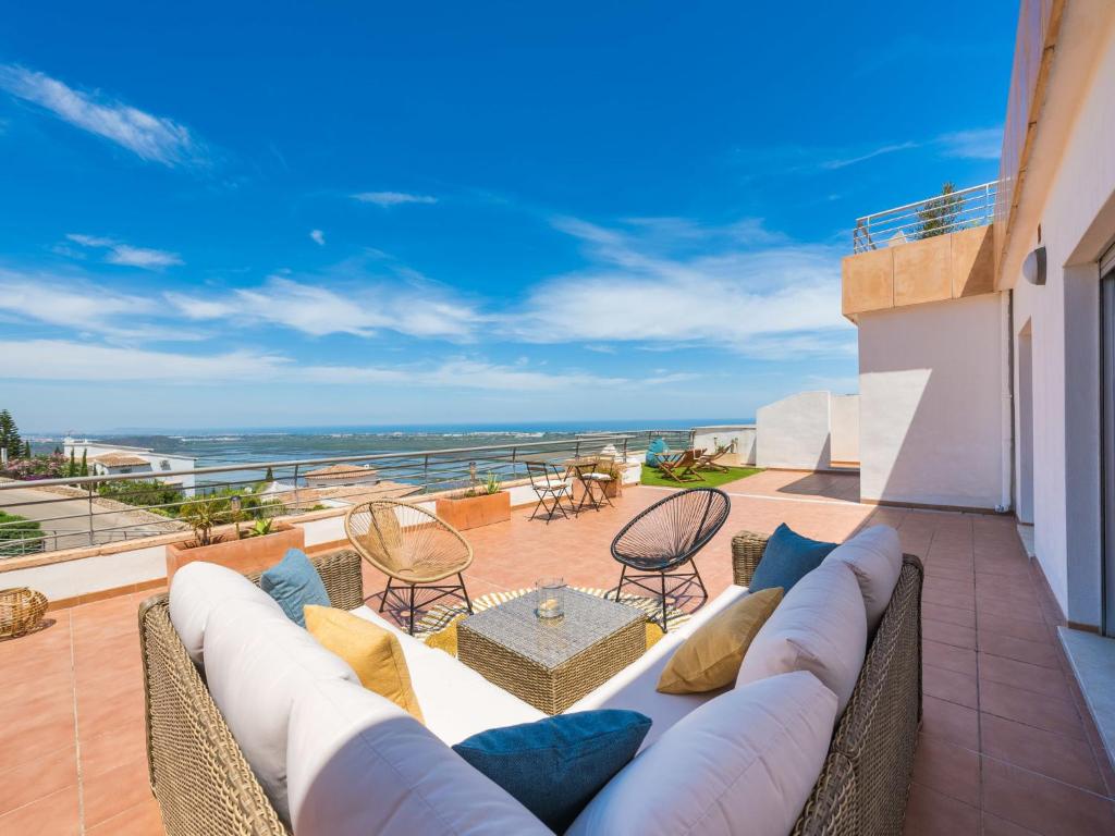 salon z kanapą i krzesłami na balkonie w obiekcie Apartment Cima del Mar-9 by Interhome w mieście Pego