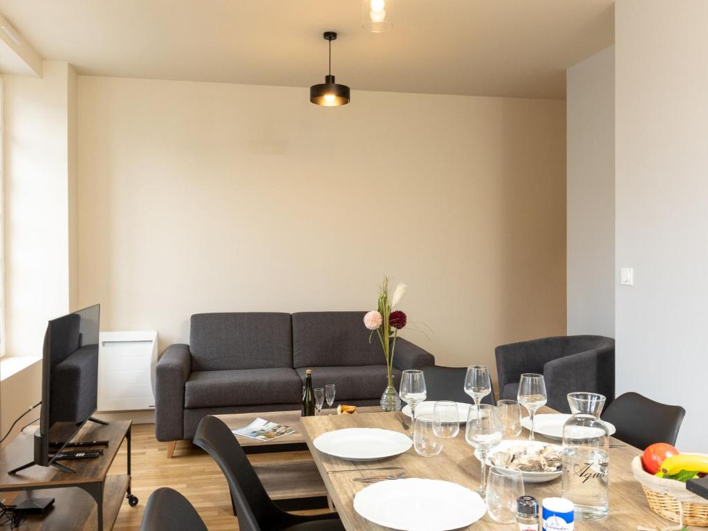 a dining room with a table and a couch at Apartment Plasenn by Interhome in Saint Malo