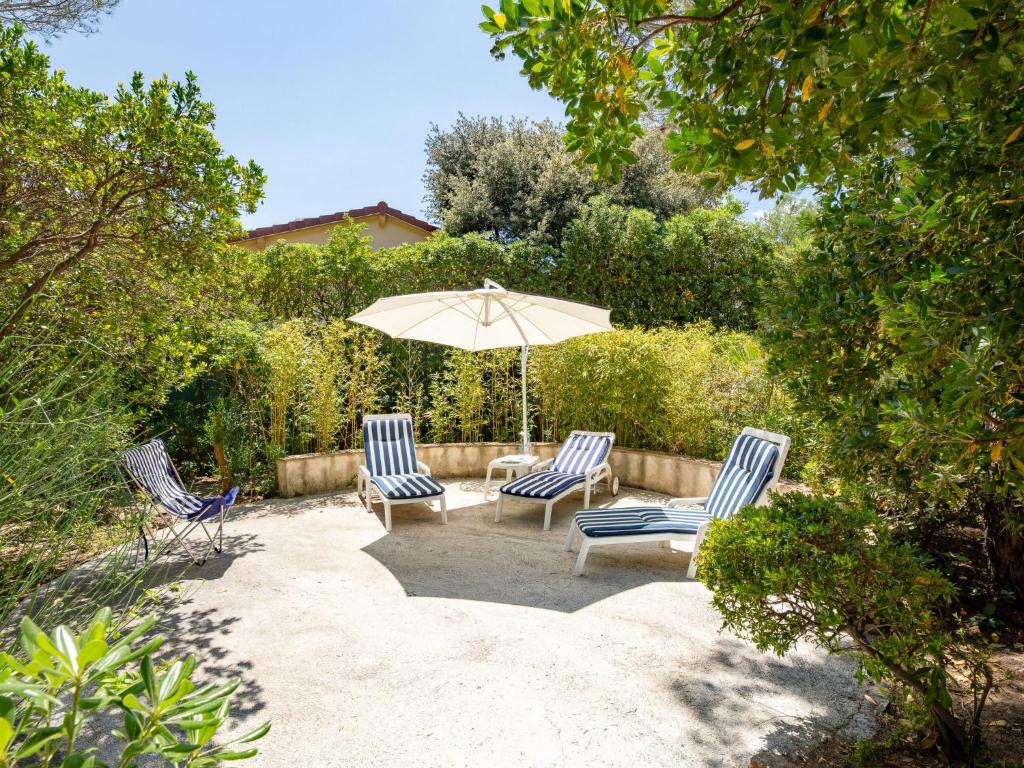 eine Terrasse mit 2 Stühlen und einem Sonnenschirm in der Unterkunft Villa Les Dauphins by Interhome in Saint-Aygulf