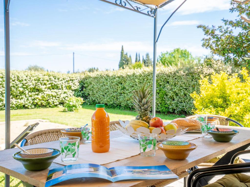 - une table avec un bol de fruits et une bouteille de jus d'orange dans l'établissement Apartment La Coraline by Interhome, à La Crau