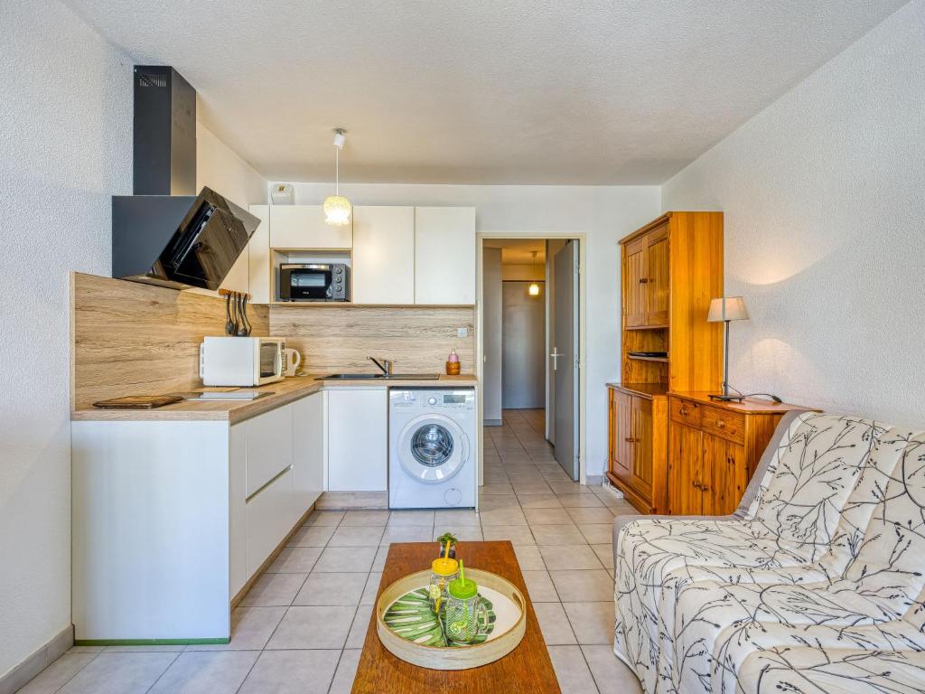 un salon avec un canapé et une cuisine dans l'établissement Apartment Le Sunset-Cap Sud-23 by Interhome, au Cap d'Agde