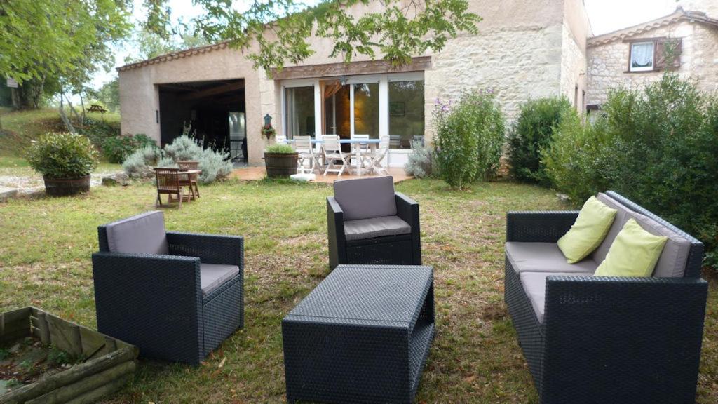 un grupo de sillas y mesas en un patio en Gîtes du Rouyre La Grange, en Réalmont