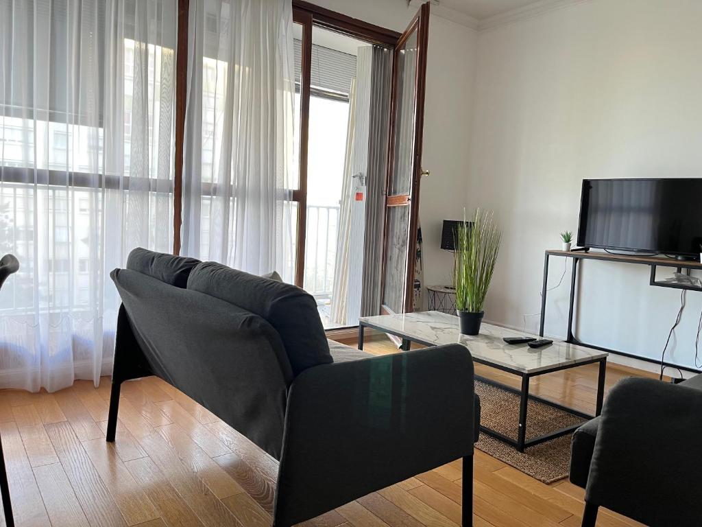a living room with a couch and a tv at Appartement T5 standing 104m2 in Orléans
