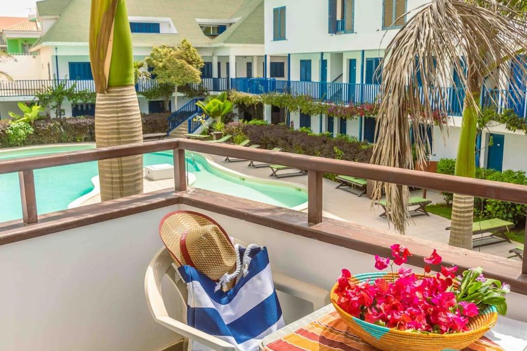 a table with a basket of flowers on a balcony at Leme Bedje - Two bedroom, Pool & Wifi in Santa Maria