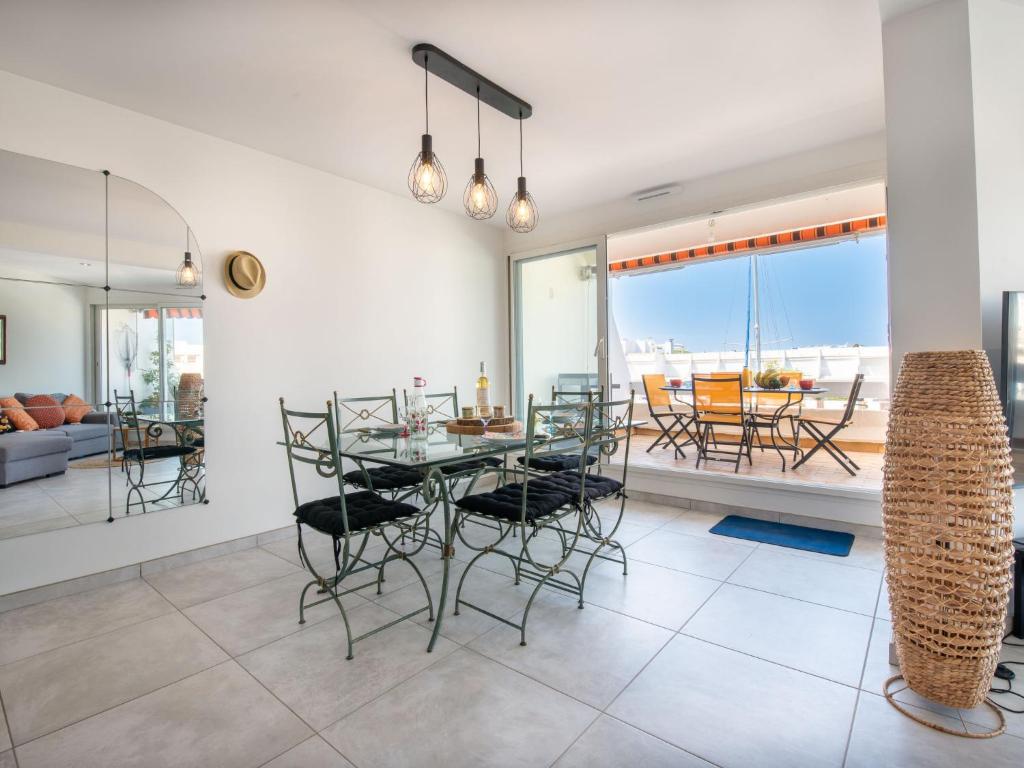 une salle à manger et un salon avec une table et des chaises dans l'établissement Apartment Le Nirvana-3 by Interhome, au Grau-du-Roi