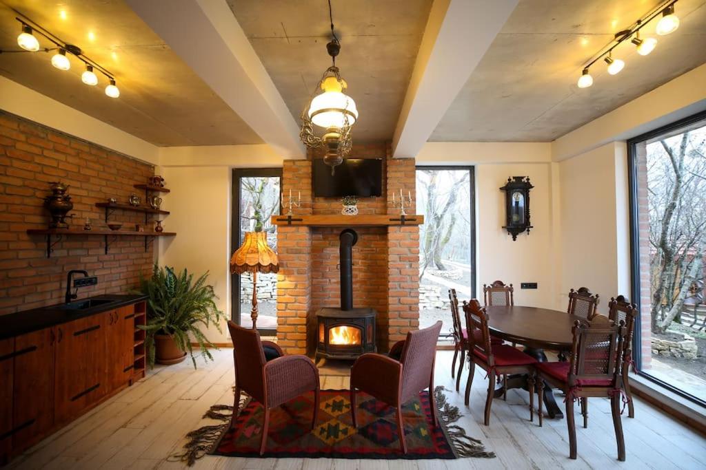a living room with a table and a fireplace at Villa Vejini in Mamkoda