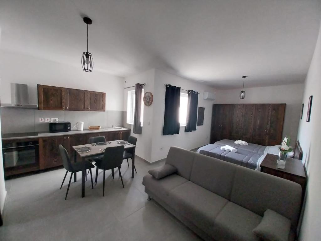 ein Wohnzimmer mit einem Sofa, einem Bett und einem Tisch in der Unterkunft St gaetans studio apartment 6A in Tas-Samra