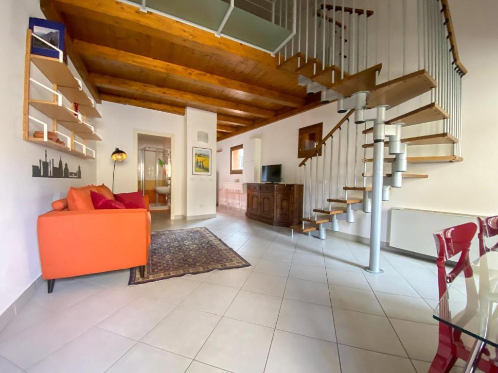 an open living room with an orange couch and stairs at Apartment Orcagna apartment by Interhome in Florence