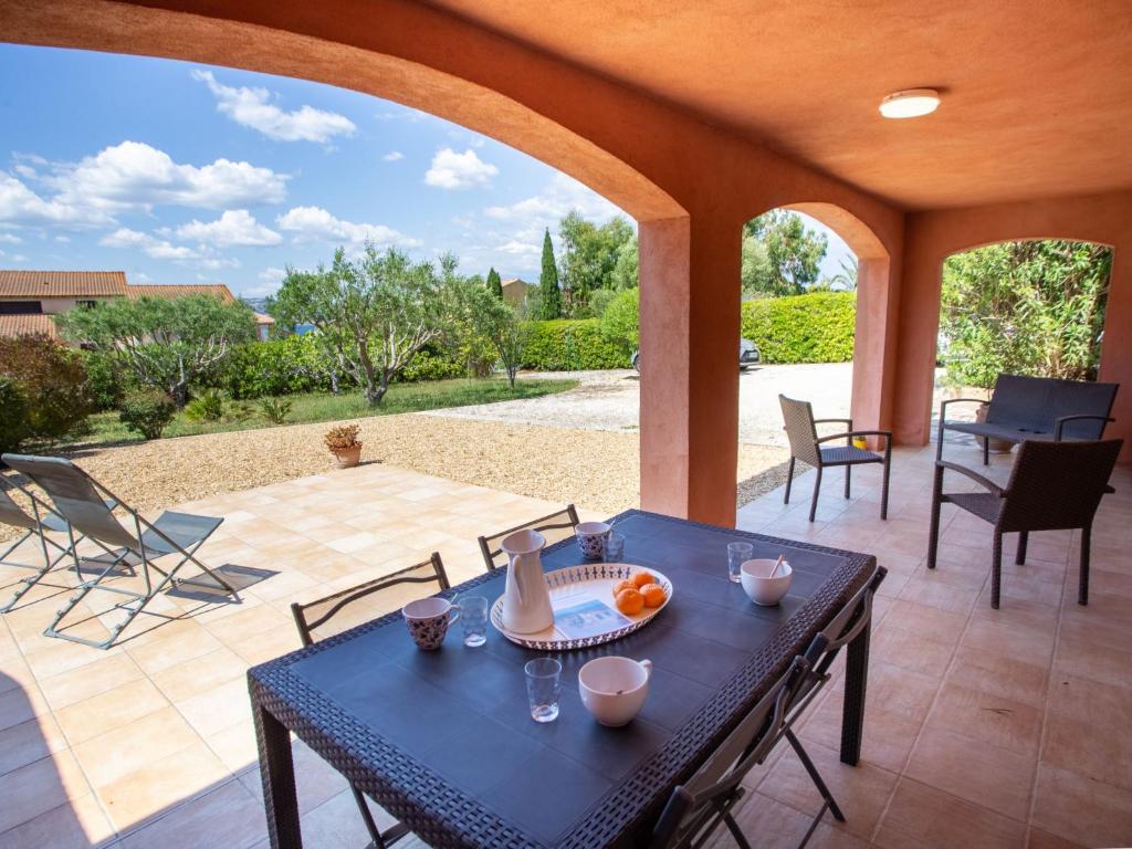 a patio with a black table and chairs on a patio at Holiday Home Villa Clair de Lune by Interhome in Hyères