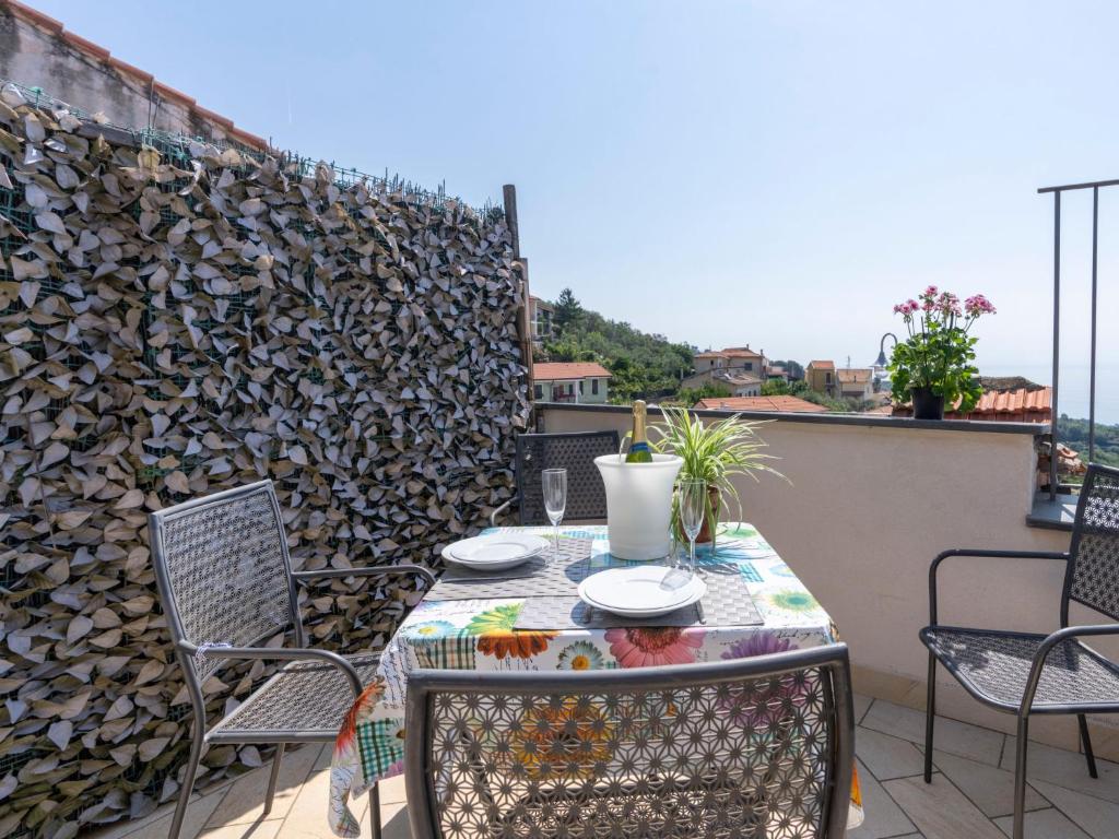 d'une terrasse avec une table, des chaises et un mur. dans l'établissement Apartment Fico by Interhome, à Terzorio