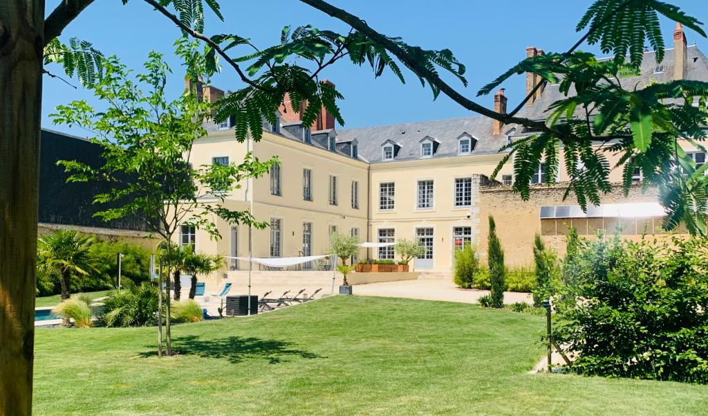 拉弗累什的住宿－Les Chambres de La Varenne，享有带草坪的大房子的外部景色