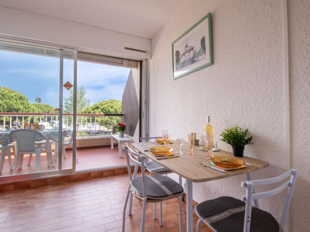 une salle à manger avec une table et des chaises et un balcon dans l'établissement Studio Le Cabestan-5 by Interhome, au Grau-du-Roi