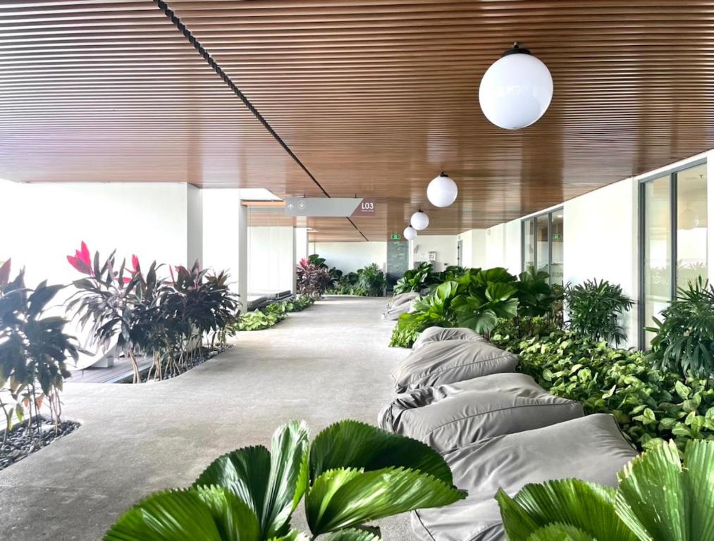 einen Flur mit Topfpflanzen in einem Gebäude in der Unterkunft Compass One Building - Luxury Apartments in Ấp Phú Thọ