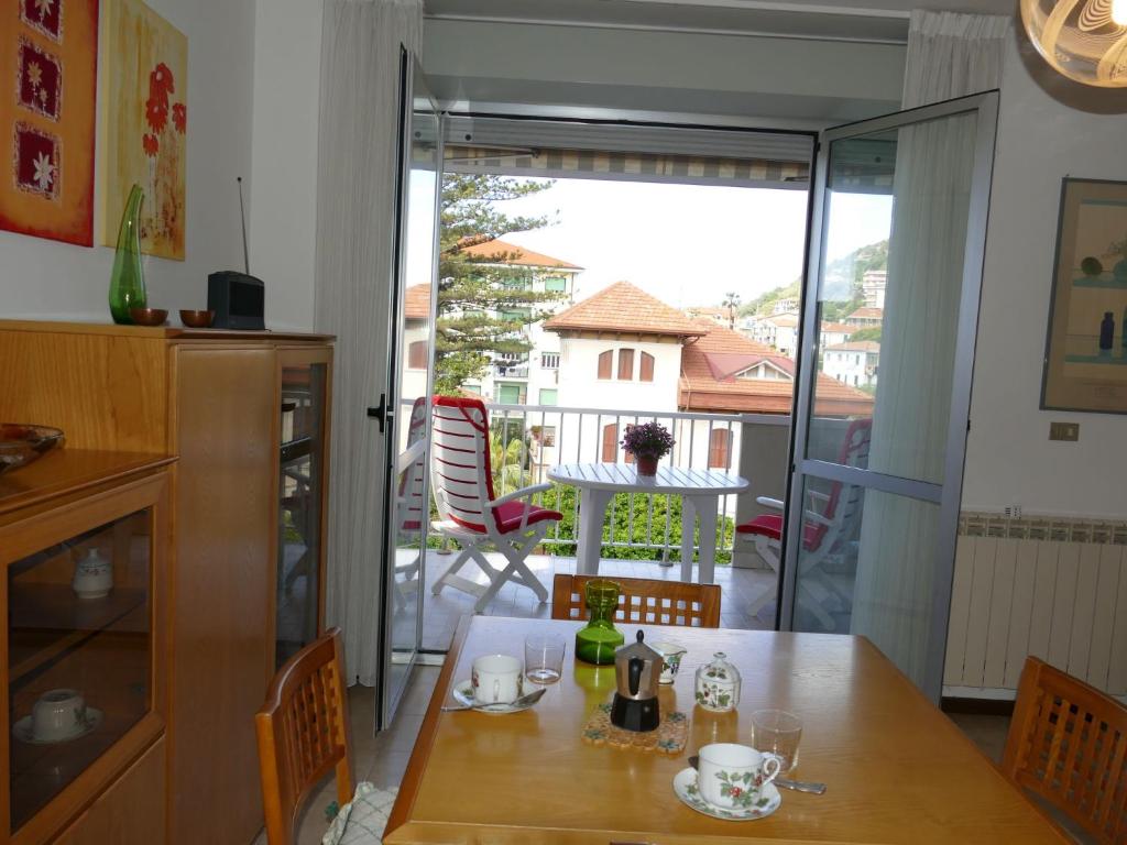 ein Esszimmer mit einem Tisch und Blick auf einen Balkon in der Unterkunft Apartment Home Sweet Home by Interhome in Riva Ligure