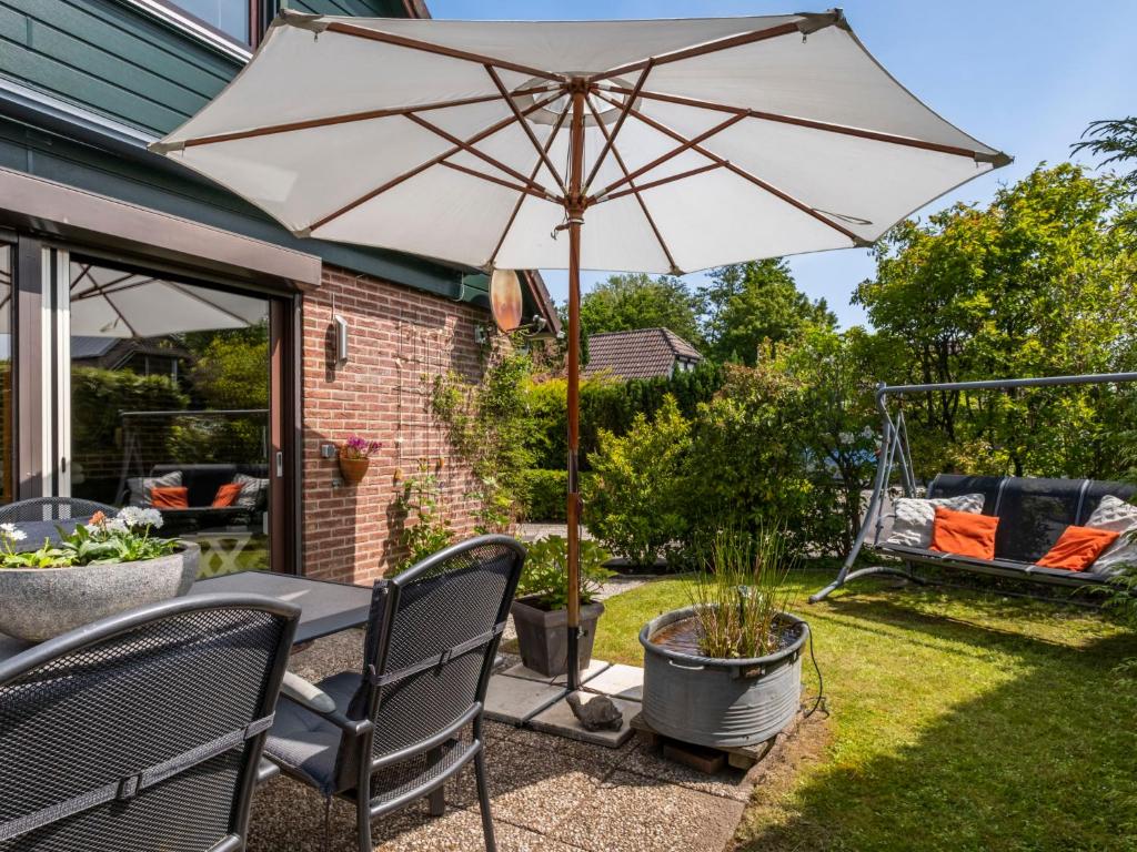 un patio con mesa y sombrilla en Holiday Home Haus Anni by Interhome en Wolphaartsdijk