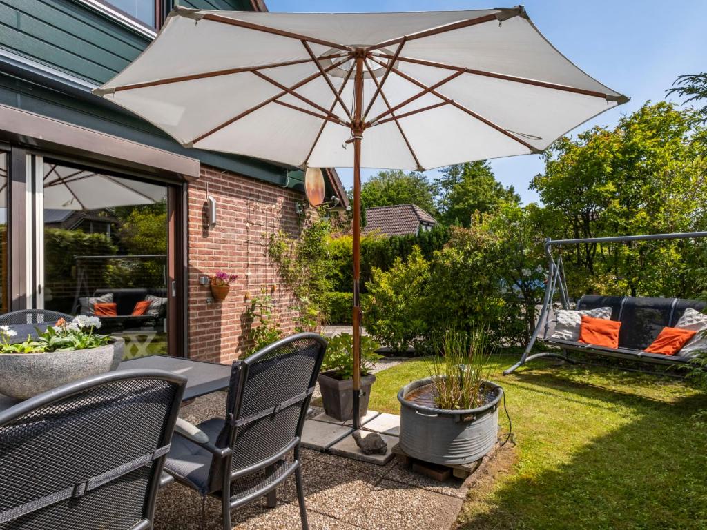 a patio with a table and an umbrella at Holiday Home Haus Anni by Interhome in Wolphaartsdijk