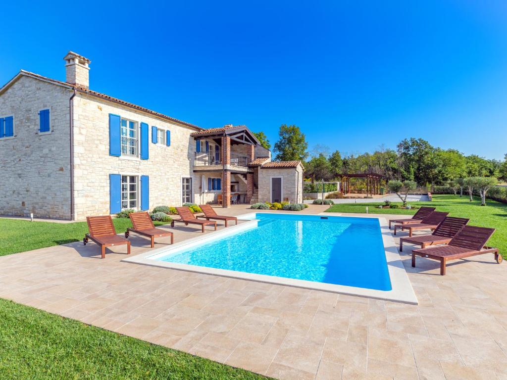una piscina con sillas y una casa en Holiday Home Villa Farfalla by Interhome, en Tinjan
