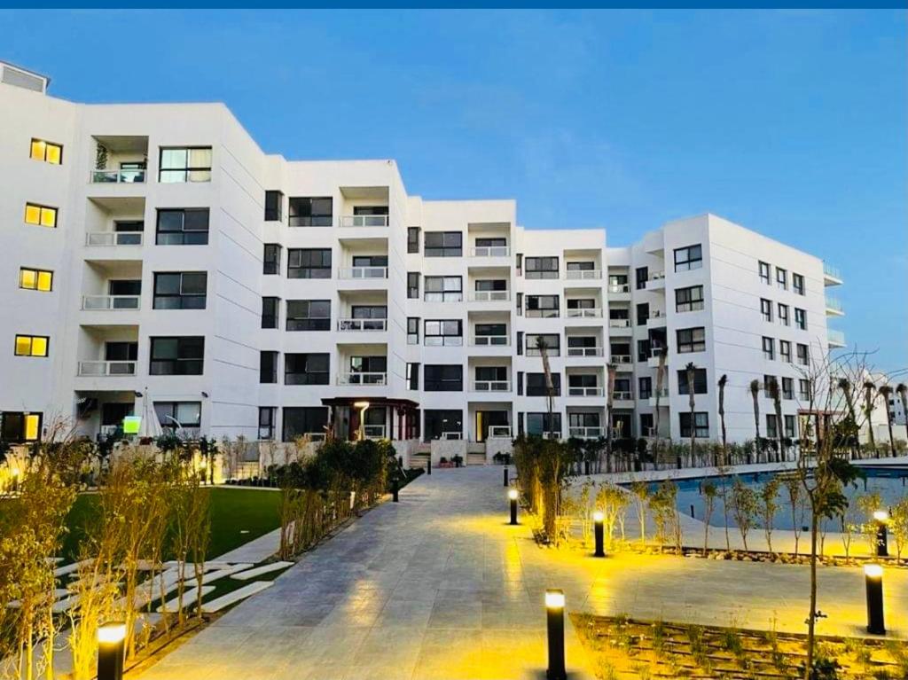Porto Said Tourist Resort Luxury Hotel Apartment في بورسعيد: عمارة سكنية كبيرة بيضاء مع ساحة فناء