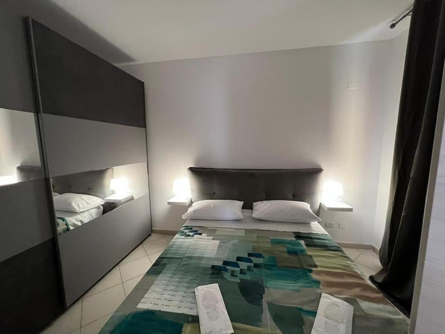 een slaapkamer met een bed met een kleurrijke deken erop bij La casa verde di Chicchi in Elmas