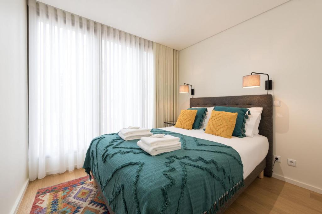 a bedroom with a bed with a green blanket at AgapeStay Family House in Porto