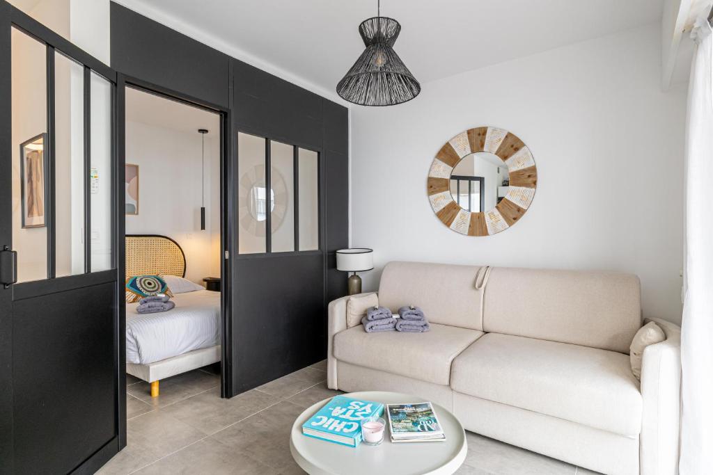 ein Wohnzimmer mit einem Sofa und einem Tisch in der Unterkunft CMG - Bel appartement avec balcon - 200m de la plage in Juan-les-Pins