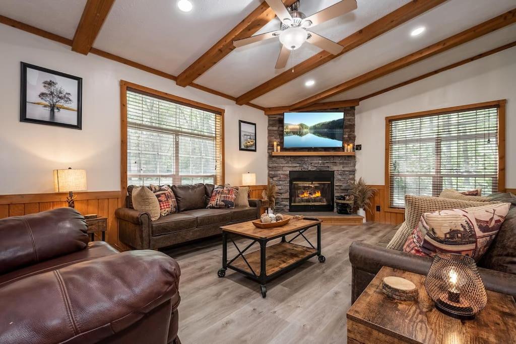 a living room with leather furniture and a fireplace at *Entire House • Sleeps 9 • Hot tub • Pets Welcome* in McHenry