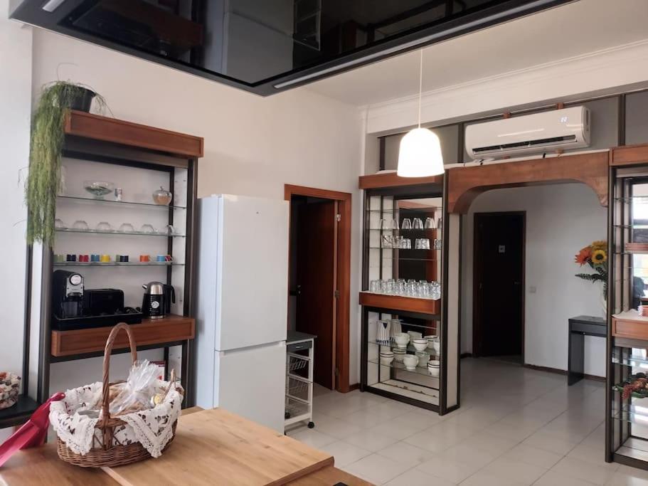 a kitchen with a white refrigerator and a table at Casa da Farmácia - Paredes de Coura in Paredes de Coura