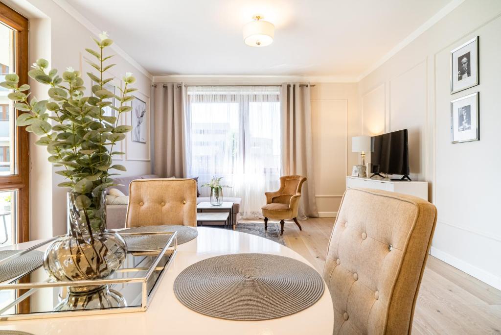 sala de estar con mesa de cristal y sillas en ApartamentySnu, Słoneczny Glam z parkingiem, Centrum, en Radom