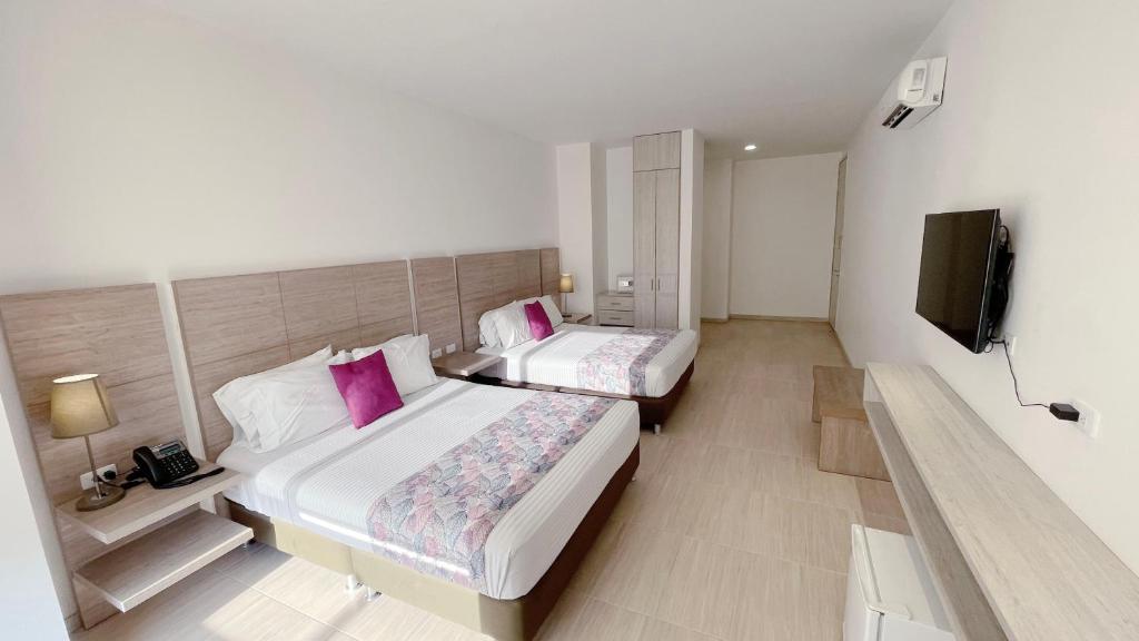 sypialnia z 2 łóżkami i telewizorem z płaskim ekranem w obiekcie Hotel MS Pacifico Chipichape w mieście Cali