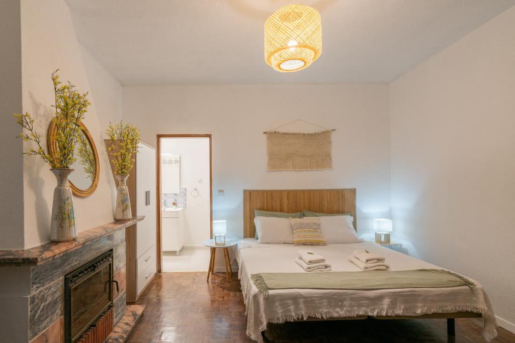 um quarto com uma cama, uma lareira e um espelho em Vivenda Aromas do Algarve em Monte Raposo