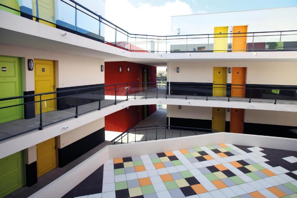 une vue d'un bâtiment avec des portes colorées dans l'établissement 315 Studio Cosy Perpignan, à Perpignan