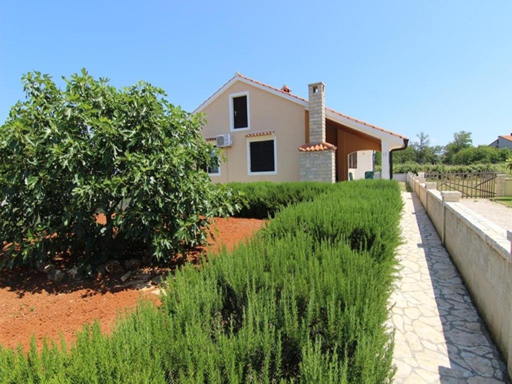 una casa con un muro di contenimento di fronte a un cortile di Holiday Home Deni a Privlaka (Brevilacqua)