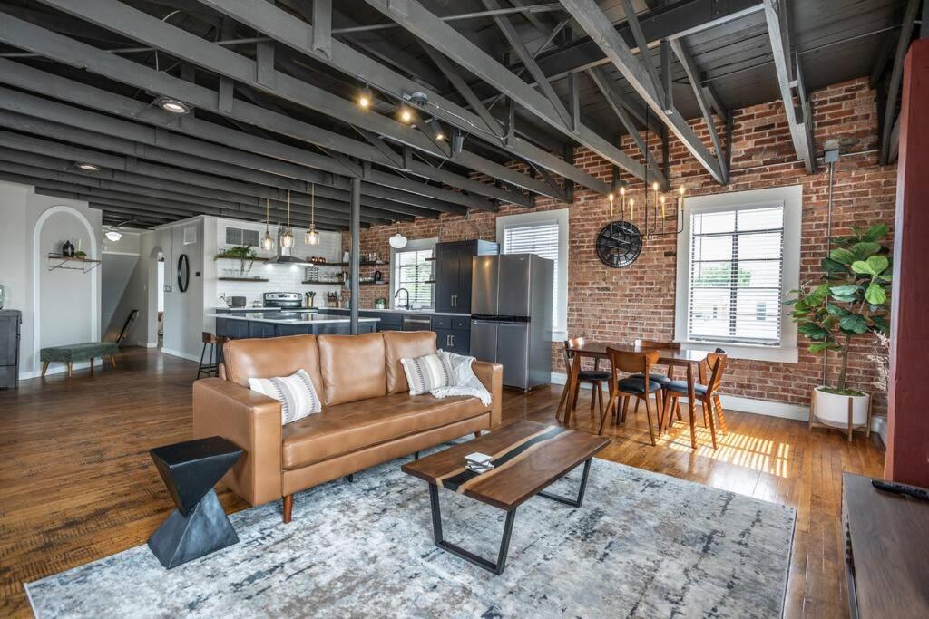 The Loft at 113 - Gateway to the North Texas Hill Country في Muenster: غرفة معيشة بها أريكة وطاولة