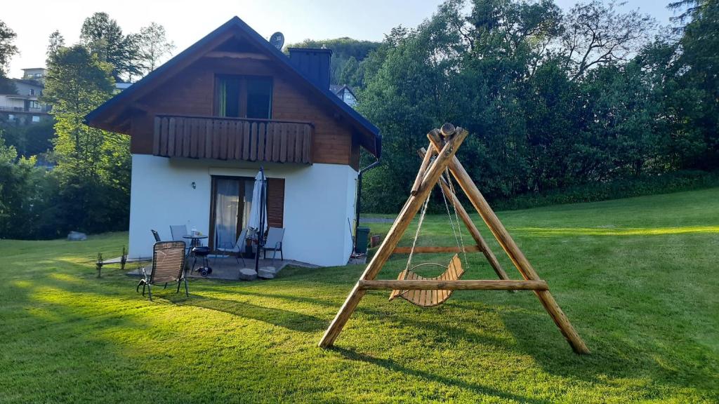 a swing set in front of a small house at Domki Partecznik Wisla in Wisła