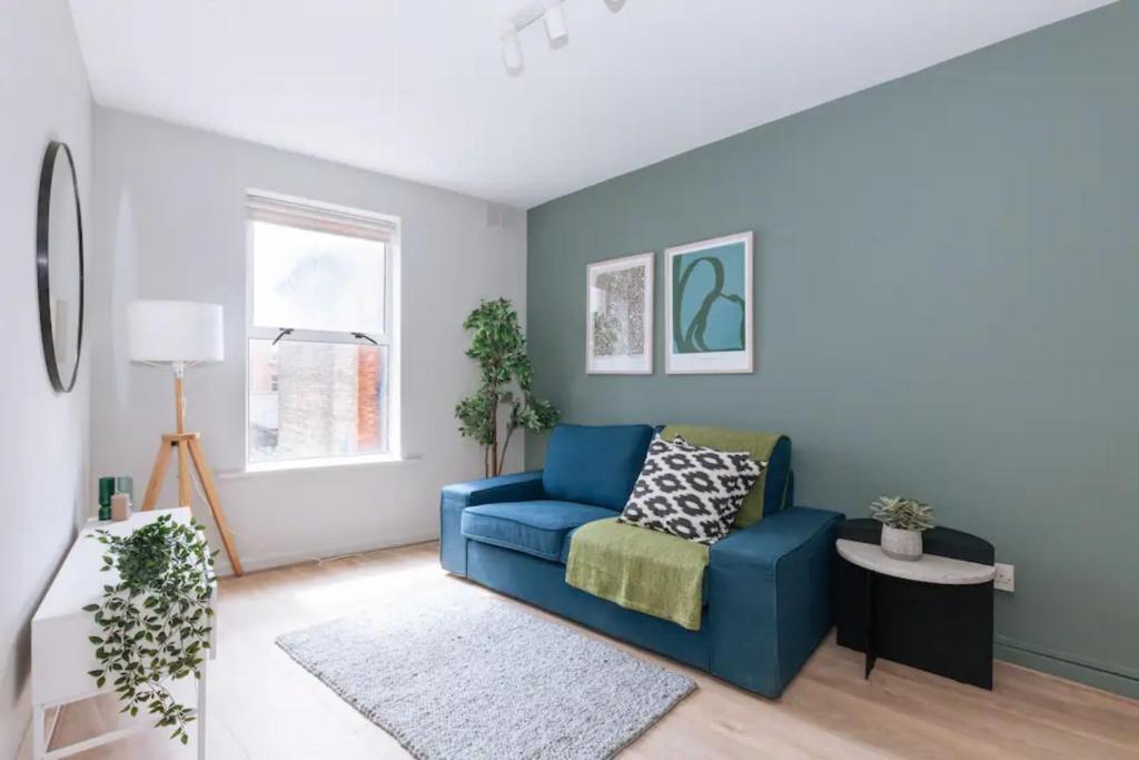 a living room with a blue couch and a window at Relaxing 1BD Flat with a Roof Terrace - Portobello in Dublin